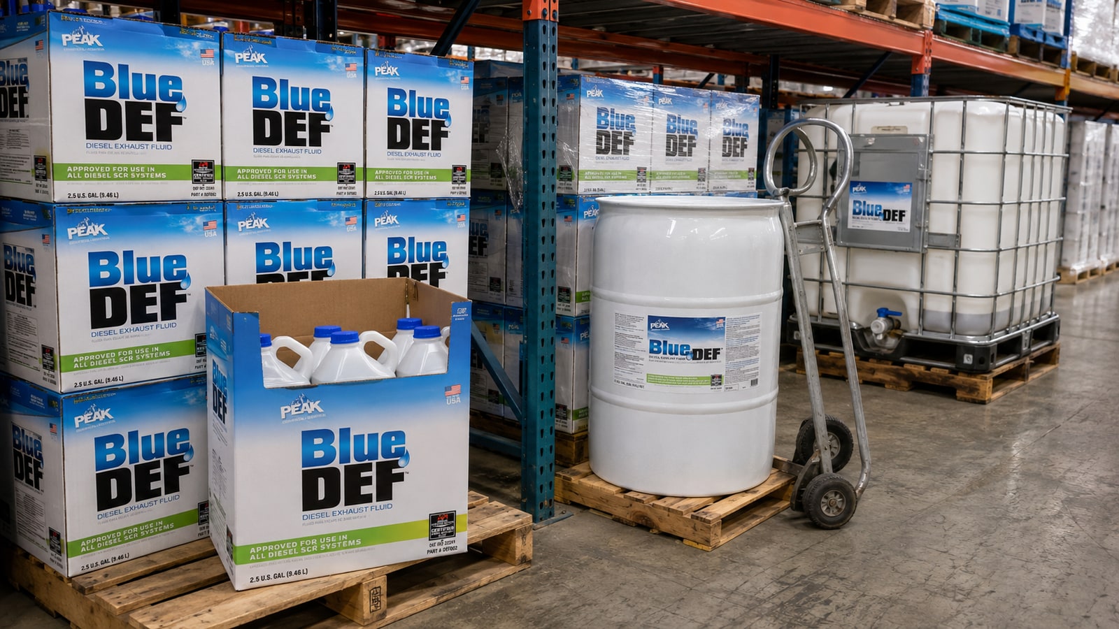 Pallets of PEAK BlueDEF jugs, a 55-gallon DEF drum, and a DEF tote in a South Florida wholesale distributor storage bay